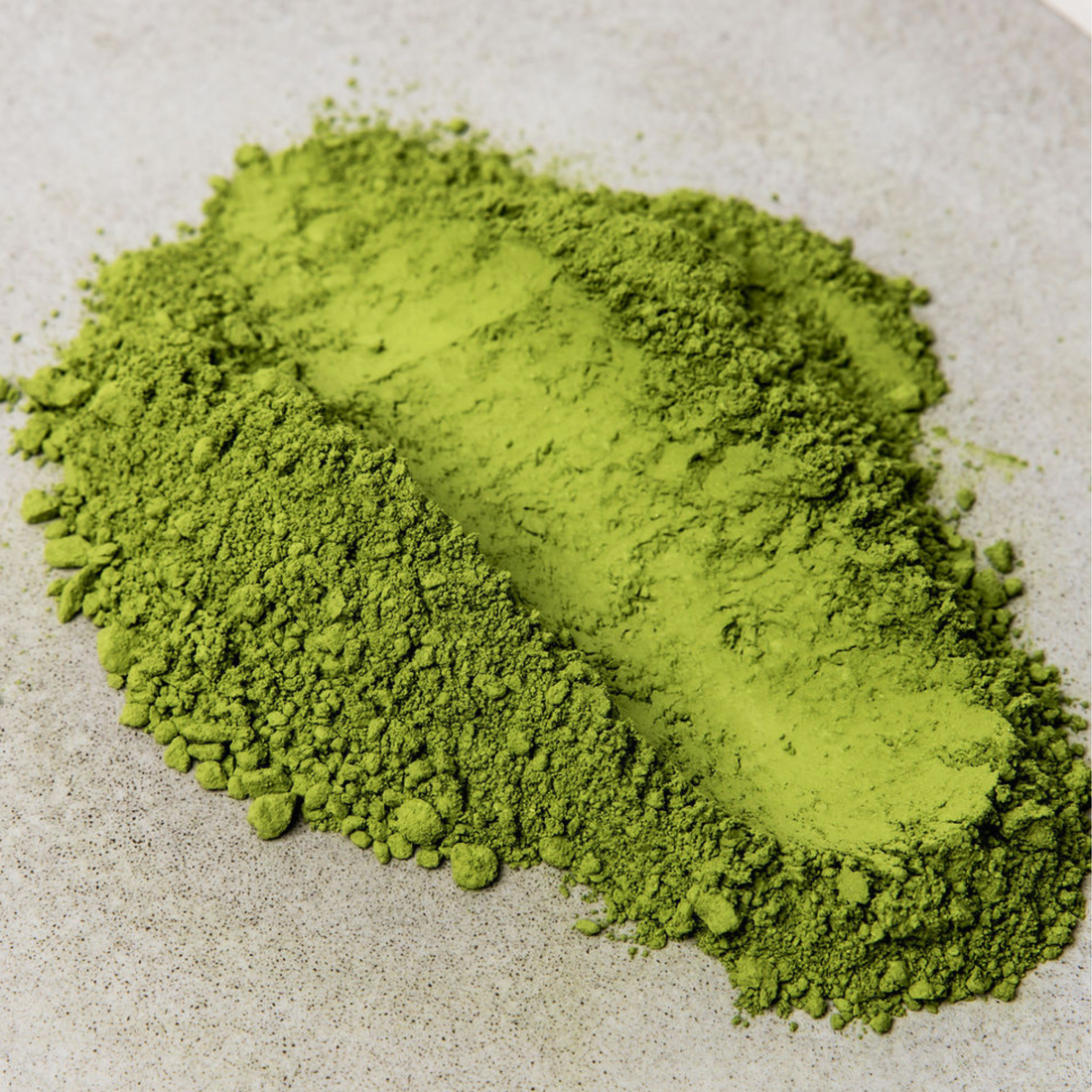 Brown paper package with Aikenka Matcha label on a woven surface and dark background